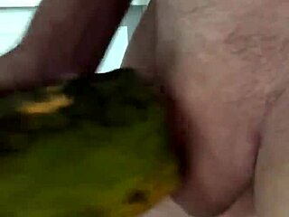 close up of mature shaved woman masturbating with papaya at home