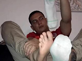 Master worships slave's feet in nylon socks during gay bdsm session.