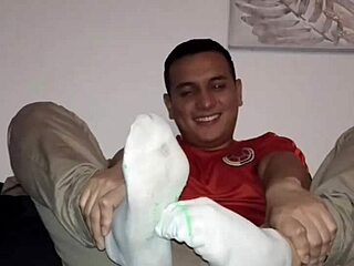Master worships slave's feet in nylon socks during gay bdsm session.