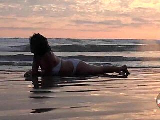 wet asian model in bikini messing around with feet on beach.