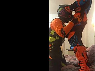 The guy in motocross gear gets a sloppy blowjob from his buddy in costumes