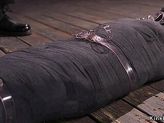 Is the mummified brunette enjoying the whipping or the pain?