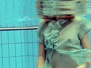 Tiny ass nastya in a dress splashes around the pool underwater with her natural tits exposed