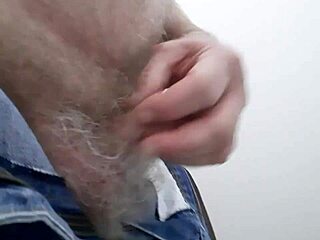 Mature man masturbates in public toilet.