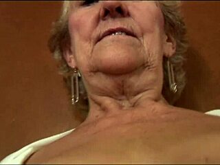 Naughty granny teases in see-through top and slip.