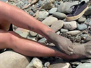 Goddess unveils messy nylon feet in torn pantyhose by river bank