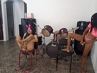 Two Colombian women one light-skinned and one dark-haired compete in a dance-off both showing off their unique styles and something unusual in their intimate areas