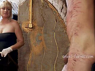 cruel blonde milf mistress brutally whips helpless guy's throbbing cock in bdsm pain fest