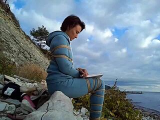 Sofi bonds against sea, tied up reading book pov